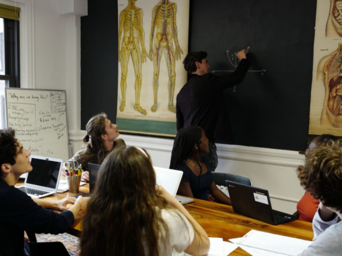 Dan Lerman teaching a small SAT class at a whiteboard