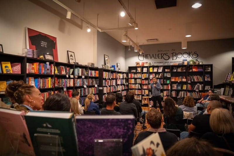 A comedian performs to a seated audience inside Chevalier's Books during the Laughs on Larchmont crawl.